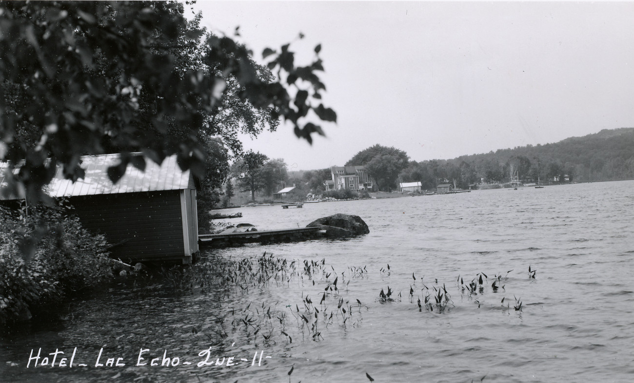 L'Hôtel Rendez-vous ou Rainville vu du Lac Écho, en arrière-plan au centre, vers 1940 - Collection Guy Thibault - © Ludger Charpentier