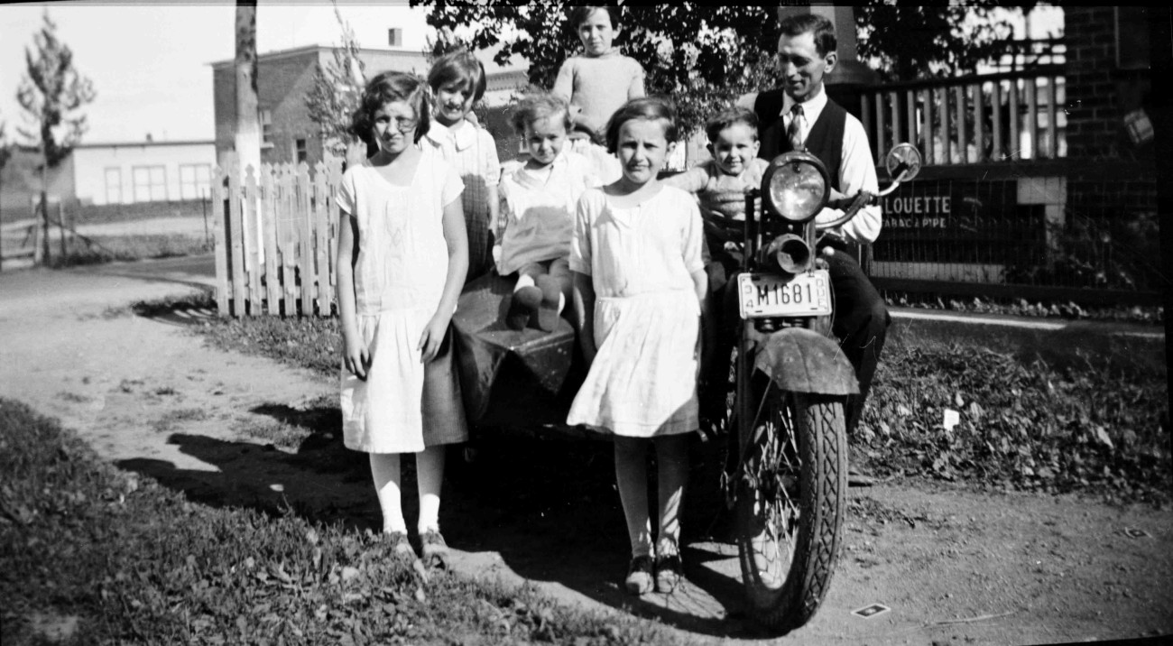 Sur la moto d'Isaïe Brosseau en 1934. On y voit Aline, Marie, Lucille, Annette, Hélène, Eugène et Isaïe - Collection Famille Brosseau