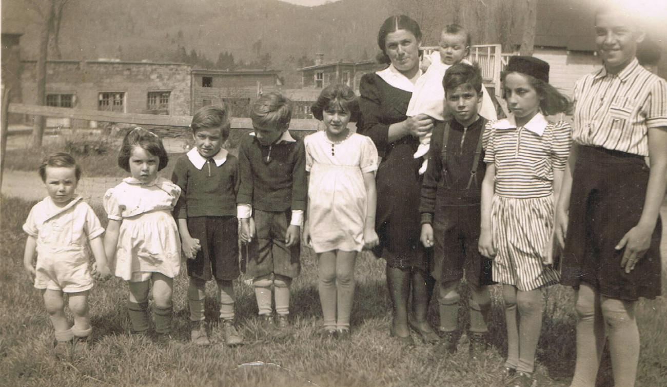 Famille de Marguerite Morin devant le Garage Morin vers 1940. On y voit Denis, Estelle, Claude, Gilberte, Cécile, Jean-Marie, Marie-Chantal, Bernadette, bébé Marie Rose dans les bras de maman Marguerite - Collection Marie Morin